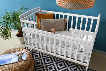 Baby crib with pillows and wooden toys in bedroom - obrazy, fototapety, plakaty