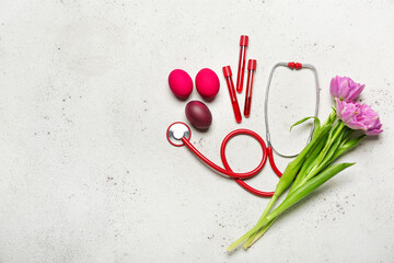 Stethoscope with test tubes, Easter eggs and flowers on light background
