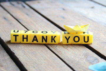 Thank you, the inscription on a wooden background.