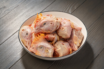 Fresh chicken heads on a simple background