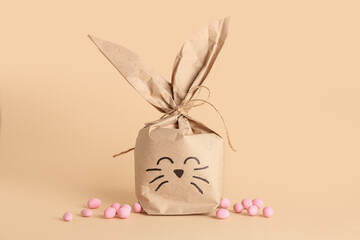 Easter bunny gift bag and candies on beige background