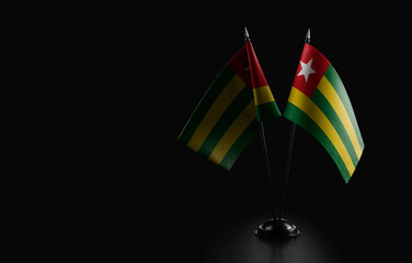 Small national flags of the Togo on a black background