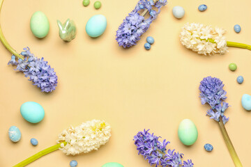 Frame made of beautiful hyacinth flowers and Easter eggs on beige background