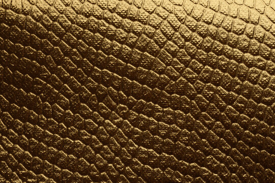 Gold and bronze gold, bronze glitter foil paper. Abstract reptile skin imitation texture background.
