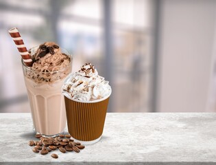 Iced latte with whipped cream and sauce on desk