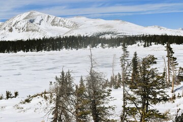 Frozen mountain lake surrounded by snow-capped peaks