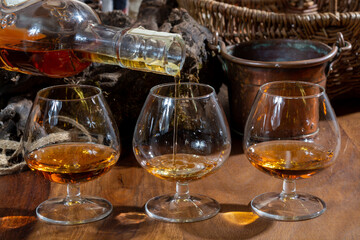 Tasting of aged french cognac brandy alcoholic drink in old cellars of cognac-producing regions Champagne or Bois, France