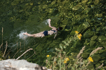 snorkeling teenage girl diving in clear mountain lake