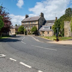 old english village and road surrounded by buildings and green trees