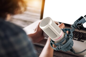 A man streaming podcast using classic microphone and laptop