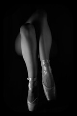 Legs with ballet shoes on a black background