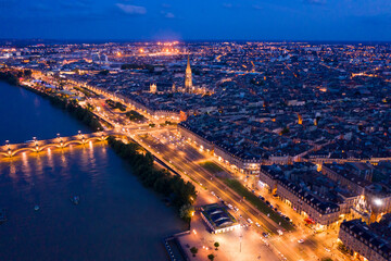 Fototapeta premium Aerial view of Bordeaux cityscape on banks of Garonne river and Pont de pierre at night