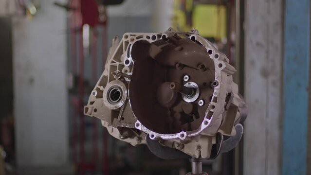 Slider Shot of Gearbox on Car Stand Lift in Repair Shop Footage.