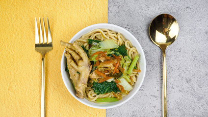 Delicious Indonesian chicken noodles called mie ayam topped with chicken meat and green vegetable. Flat Lay Concept
