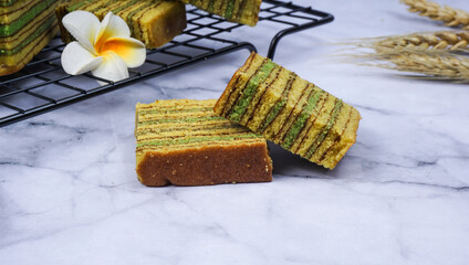 Traditional Indonesian sweet Lapis layer cake on wooden plate. Indonesian layered cake called...