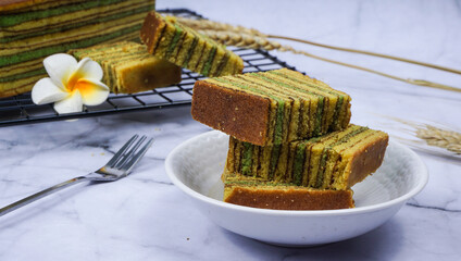 Traditional Indonesian sweet Lapis layer cake on wooden plate. Indonesian layered cake called...
