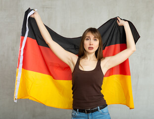 Upset female Germany team fan holding national flag - Powered by Adobe