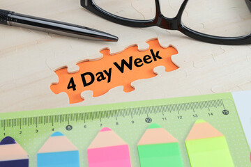 Four-day workweek concept. A 4-Day Week message on the orange-colored paper under the missing puzzles. 