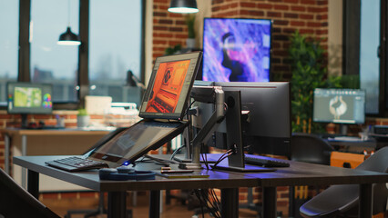 Empty creative agency studio filled with workstations to create content for modern production,...