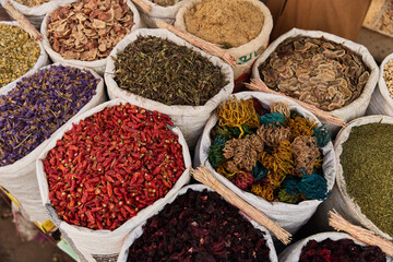 Variety organic pepper, flowers, hibiscus, herbs in sacks on sale on a farmers market.Traditional arabic market.