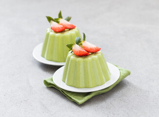 Vegan dessert. Spinach cream pudding, Panna Cotta with strawberries, on a plate on a linen napkin....