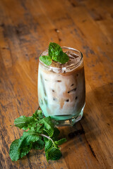 iced mint latte with fresh mint topping on wooden table