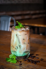 iced mint latte with fresh mint topping on wooden table