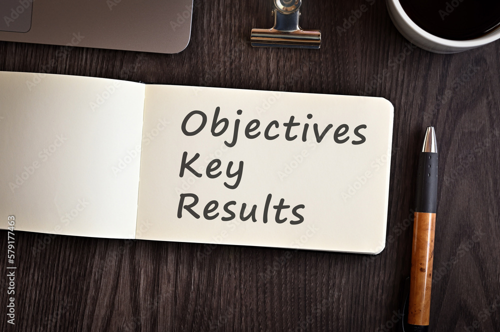 Poster there is notebook with the word objectives key results. it is an eye-catching image.