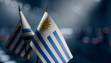 Small flags of the Uruguay on an abstract blurry background - obrazy, fototapety, plakaty