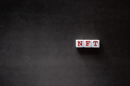 There is white cube with the word NFT. It is an abbreviation for Non-Fungible Token as eye-catching image.