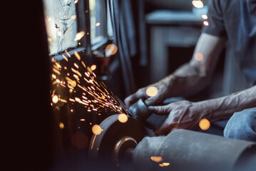 A worker works with steel with flames, close up