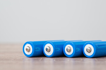 Modern blue batteries laying on the table. Close up of 18650 rechargeable batteries, energy and...