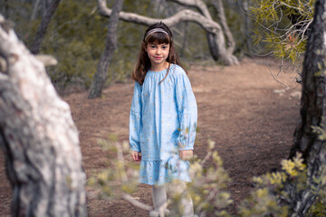 Niña paseando por el bosque mirando a su alrededor 