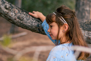 Niña paseando por el bosque mirando a su alrededor 