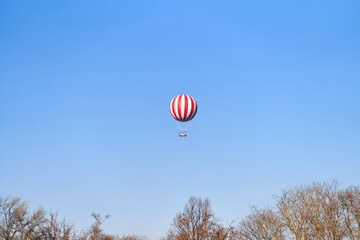 Obraz premium View of a red and white hot air balloon on a blue sky background. High quality photo