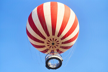 Budapest, Hungary - February 10, 2023: View of a red and white hot air balloon on a blue sky...