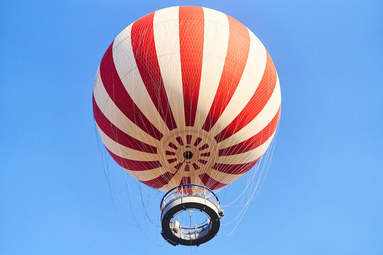 Budapest, Hungary - February 10, 2023: View of a red and white hot air balloon on a blue sky background. High quality photo