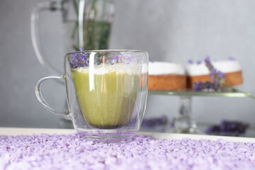 matcha green tea with mousse cakes on a table decorated with lavender flowers