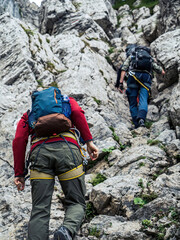 Two mountain climbers on a via ferrata route on a mountain