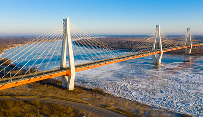 Fototapeta premium Scenic aerial view of cable-stayed bridge over frozen Oka river near Murom city of Vladimir region on sunny winter day, Russia.