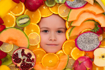 Fototapeta na wymiar Funny child eats organic fruits. Healthy meal nutrition for children. Child eat tasty fruits. Fresh fruit and child face top view. Mix of raw fresh fruits.