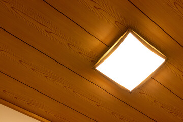 四角形の照明が取り付けられた和室の木製天井

