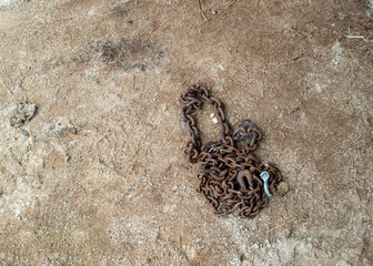 Old log chain on dry brown ground