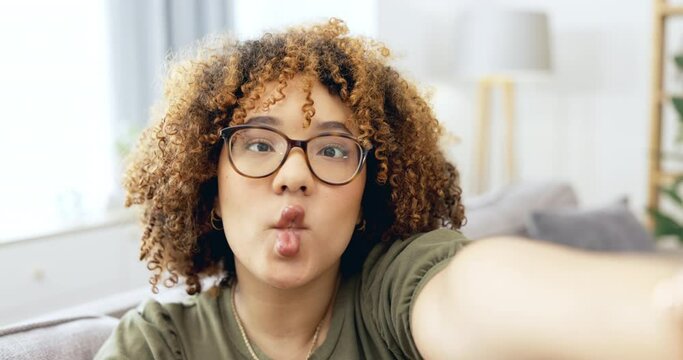 Black woman, selfie and silly face of a young person on a living room sofa with happiness. Portrait, influencer and smile of a female on a home couch taking a profile picture on social media