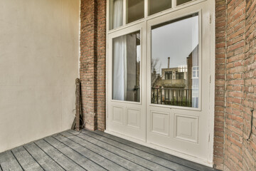 a front porch with an open door and brick wall on the side of the house that has been painted white