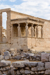 Fototapeta na wymiar The Erechtheion or Temple of Athena Polias, the Ancient Greek temple at the Acropolis in Athens. The columns that support the porch are six female figures.
