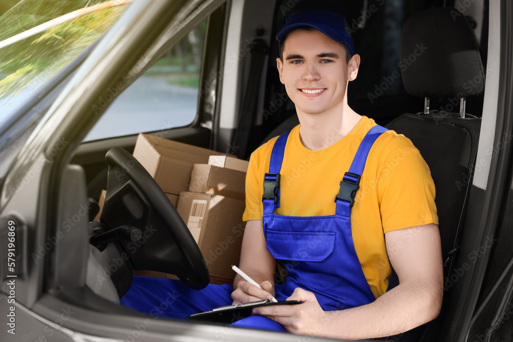 Wall mural Courier with clipboard checking packages in car