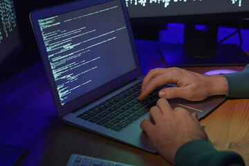 Hacker working with computers at wooden table, closeup. Cyber attack