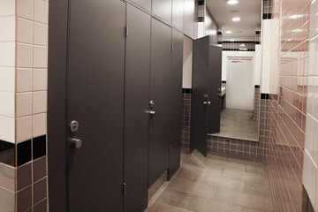 Public toilet interior with stalls and tiled walls