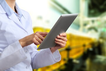 Young factory worker control ingredients with digital tablet